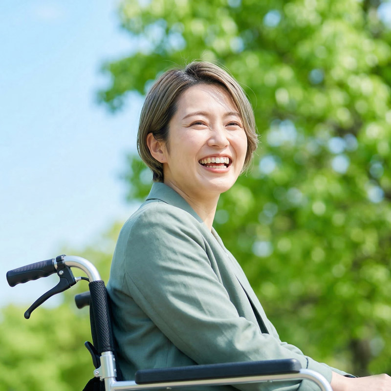 車いすの人物と支援者の笑顔